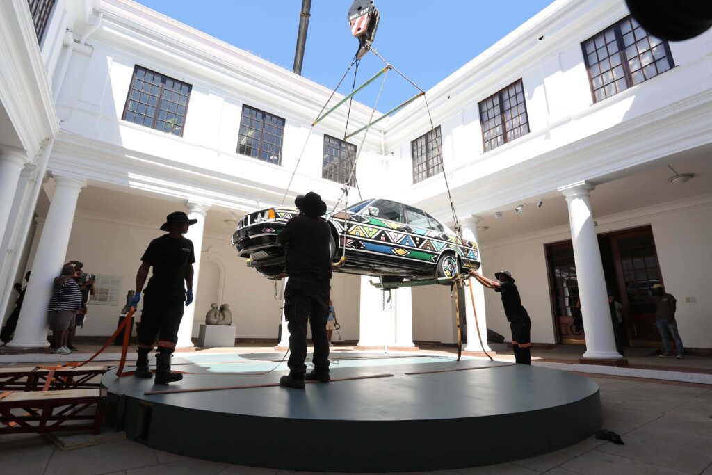 A Retrospective Unveiling: A Life of Artistic Brilliance 10 Car being lifted