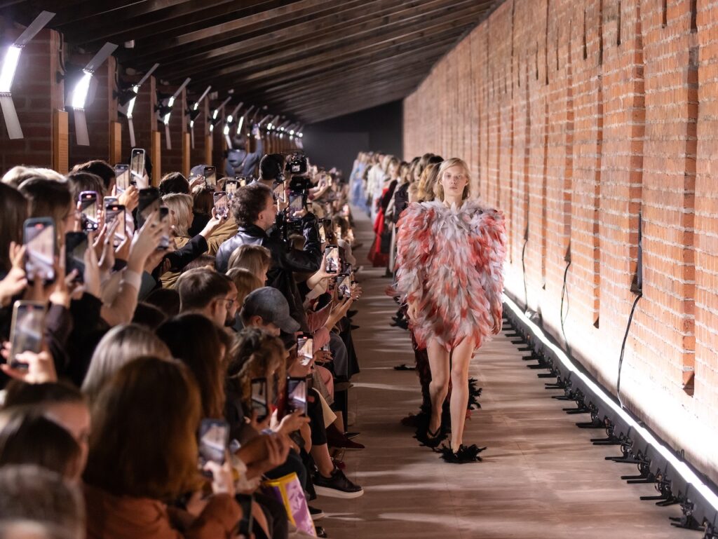 Moscow Fashion Week Kicks Off With A Dazzling Showcase Of Emerging Industry Stars 2 Models heading down the runway at Moscow Fashion week while being photographed by onlookers