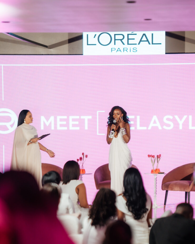 L’Oréal Paris Glycolic-Bright Anti-Dark Mark Serum displayed elegantly on a reflective surface, highlighting the luxury skincare innovation Melasyl™ for all skin tones with Ama Qamata