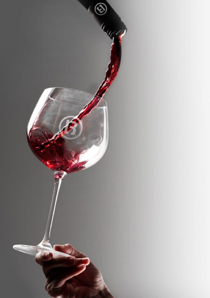 Black Wines branded red wine being poured into Black Wines branded glass