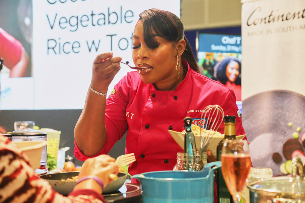 A chef plating a dish during a live cooking demonstration at the IMBO Theatre of Taste, The Good Life Show Johannesburg