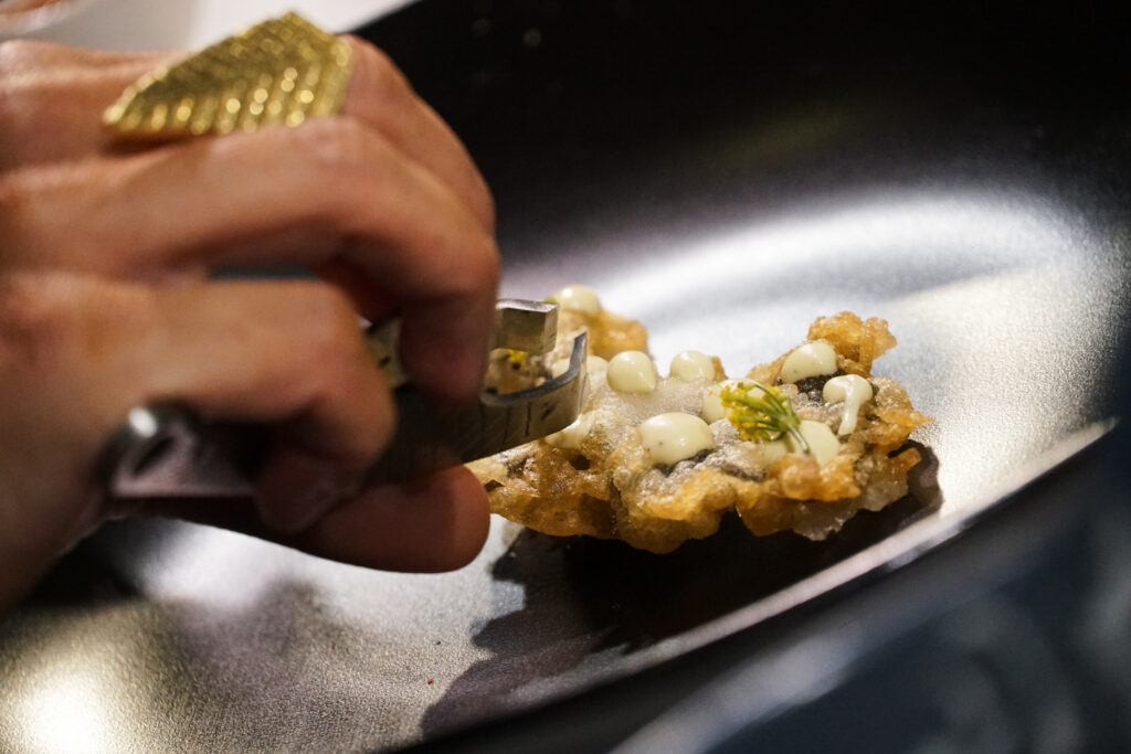 A chef plating a dish during a live cooking demonstration at the IMBO Theatre of Taste, The Good Life Show Johannesburg