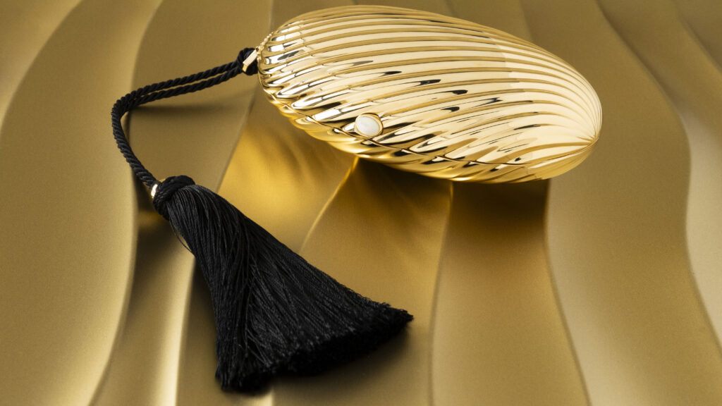 Bvlgari Melone Clutch Returns From the Archive 4 Bvlgari Melone clutch in pleated gold finish aluminium with a white mother of pearl cabochon closure and silk tassel