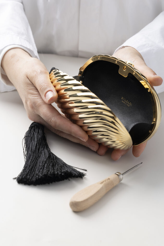 Bvlgari Melone Clutch Returns From the Archive 18 Bvlgari Melone clutch in pleated gold finish aluminium with a white mother of pearl cabochon closure and silk tassel