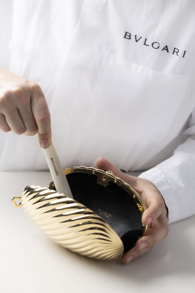 Bvlgari Melone Clutch Returns From the Archive 17 Bvlgari Melone clutch in pleated gold finish aluminium with a white mother of pearl cabochon closure and silk tassel